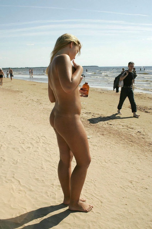 Сексапильная блондинка плескается в воде топлес на пляже