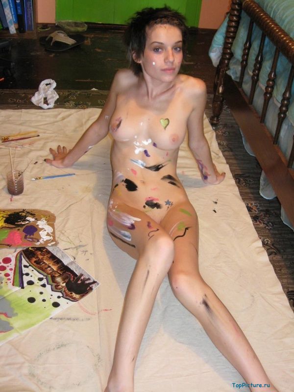 На полу художница разрисовывает красками голое тело